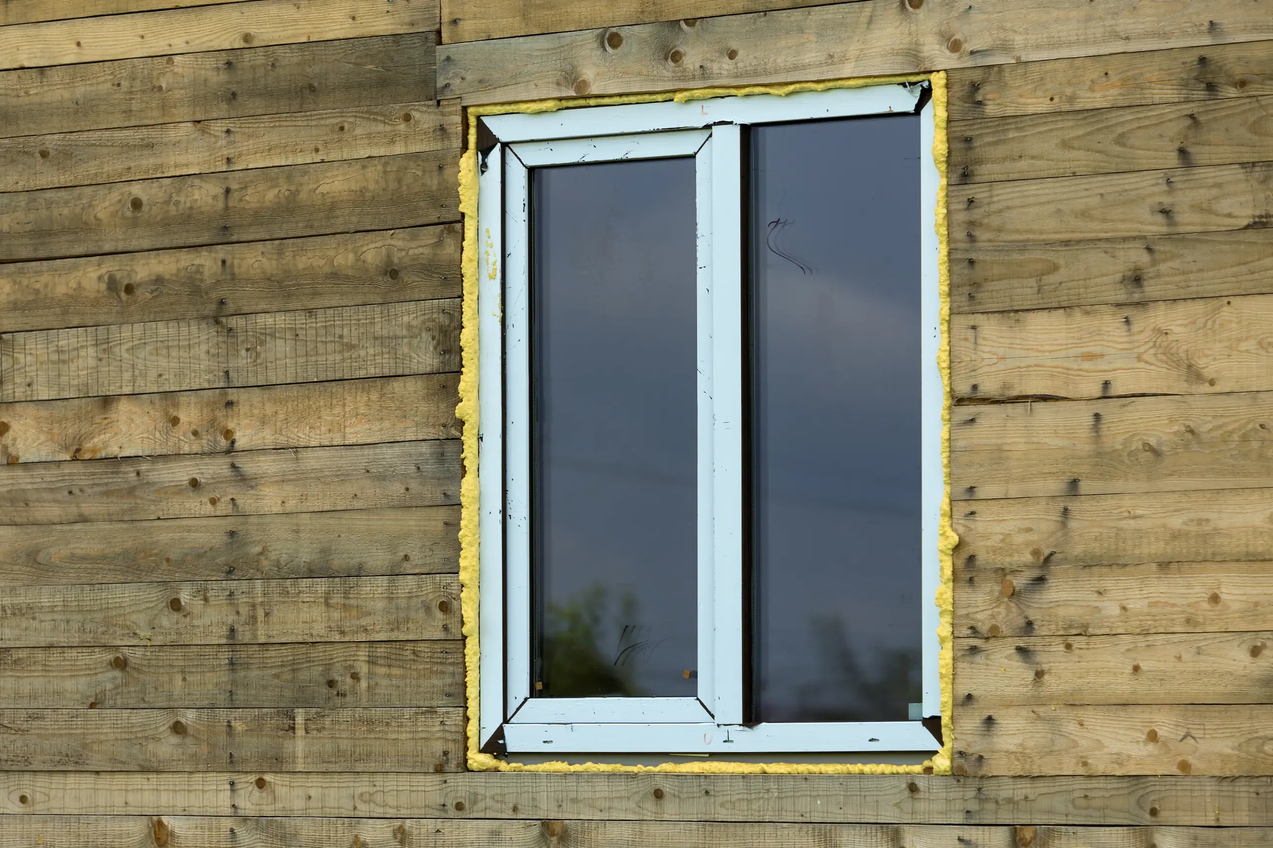 PVC Fenster mit Holzverkleidung an einer Wand