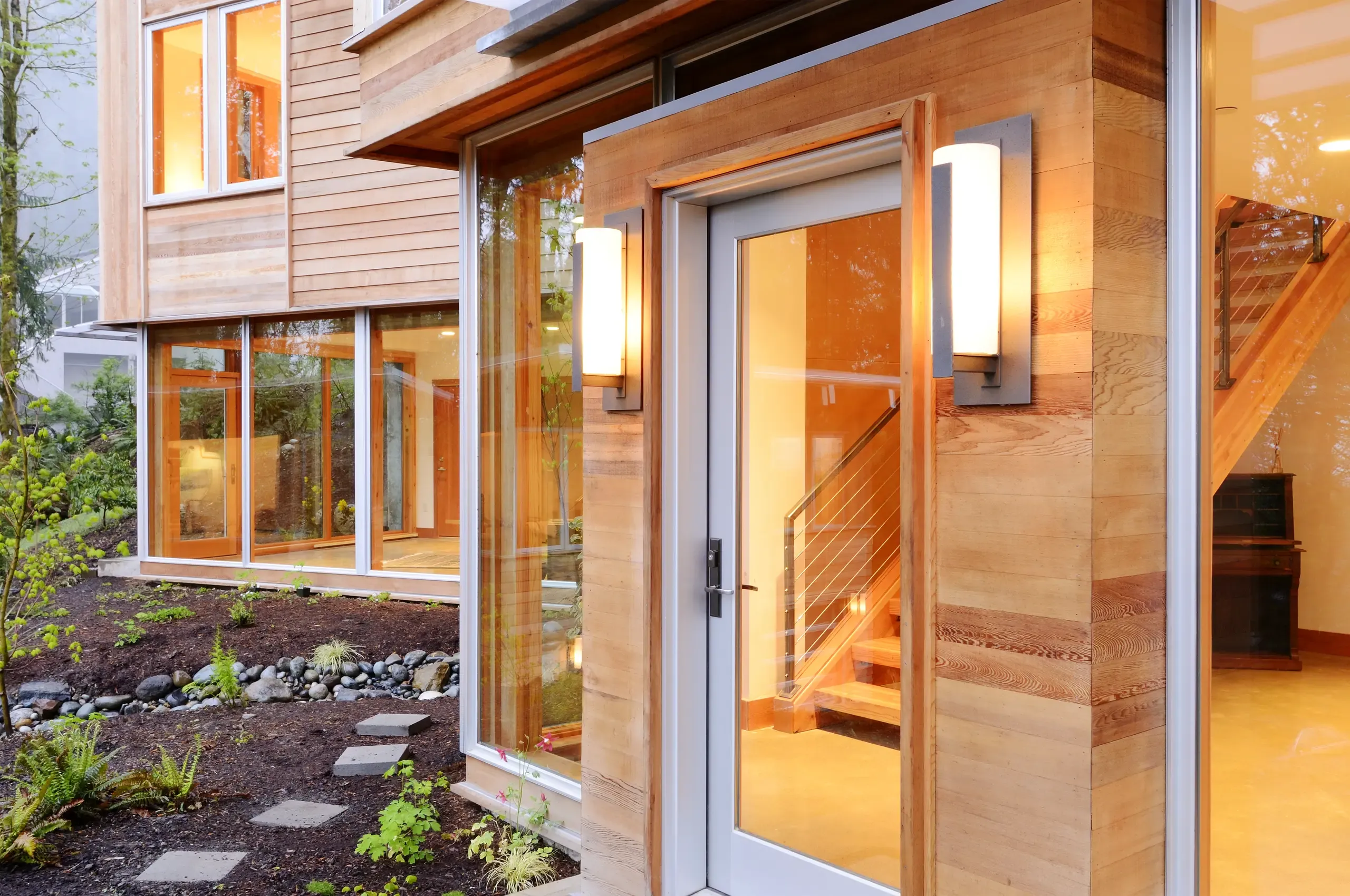 Moderne Hauseingangstür mit Holzverkleidung und großen Fenstern