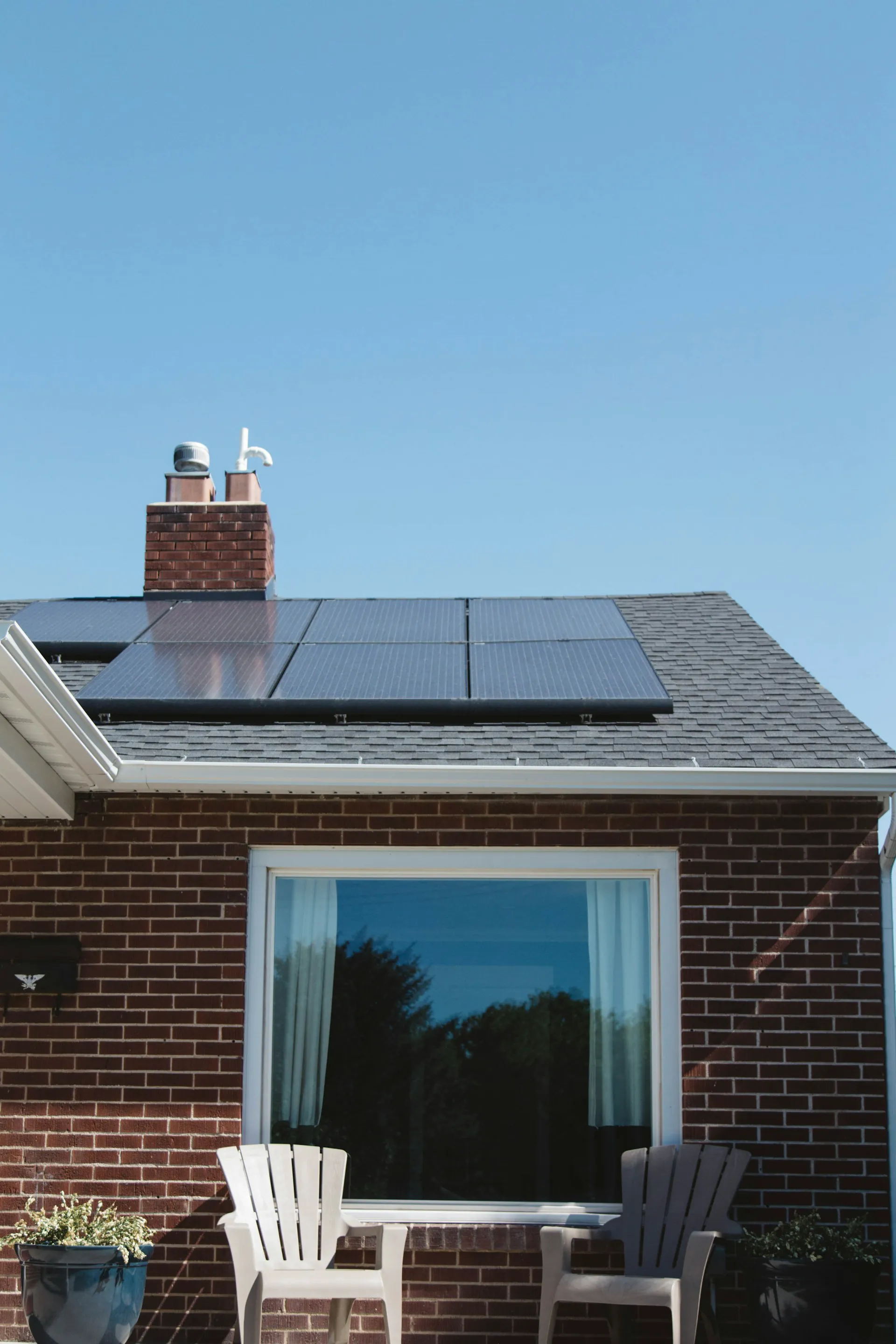Solaranlagen auf dem Dach eines Hauses mit einer Terrasse im Vordergrund